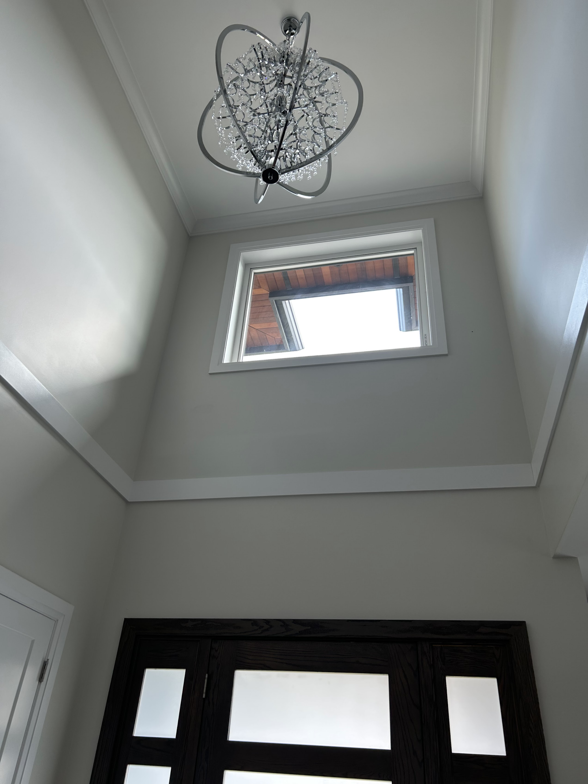 Vancouver interior with light neutral walls, white crown moulding and window trim, and a chandelier